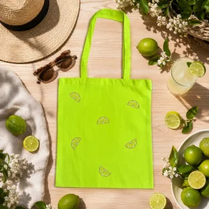 Tote bag citron vert au motif d'agrumes, creation AELA CREATIONS, pose sur une table en bois